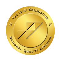 Gold circular badge labeled The Joint Commission National Quality Approval, with diagonal stripes in the center.
